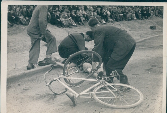 Photo cyclist is taken care of after a fall, racing bike
