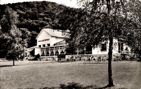 Ak Bad Harzburg am Harz, Kur-Lichtspiele Gebäude, umgeben von Bäumen und Wiese, Stühle im Freien