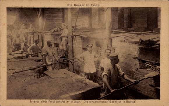 Ak De bakkers in het veld, Interieur van een veldbakkerij in het westen, De ingemetselde ovens in werking