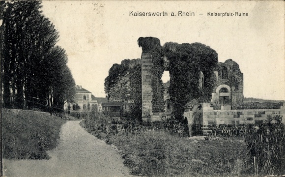 Ak Kaiserswerth Düsseldorf am Rhein, Kaiserpfalz-Ruine, Weg mit Bäumen, Gebäude im Hintergrund