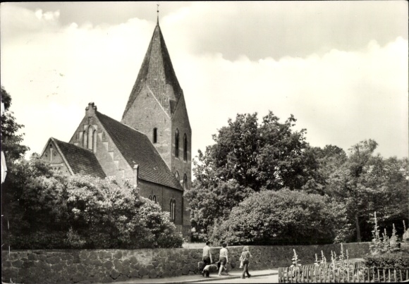 Postcard Ostseebad Rerik, church with pointed tower, visitors on the way, green trees, idyllic landscape