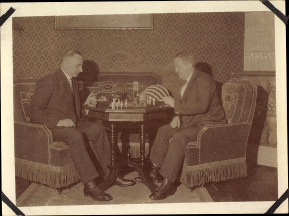 Photo Two men in suits play chess