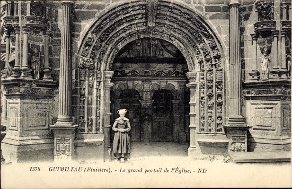 KP Guimiliau Finistère, kobieta przed portalem kościoła, duża kamienna architektura, Finistère