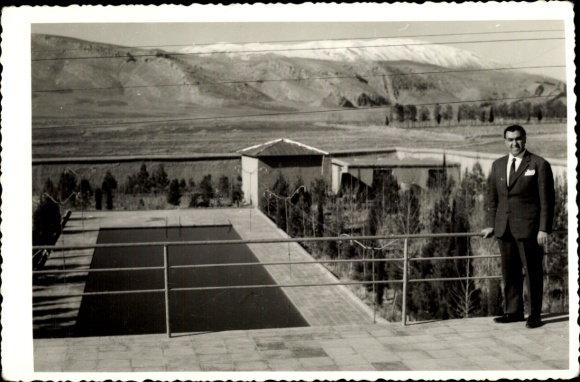 Ak Persepolis Shiraz Iran, Mann in Anzug, Villa, Pool, Berglandschaft, sonnige Atmosphäre
