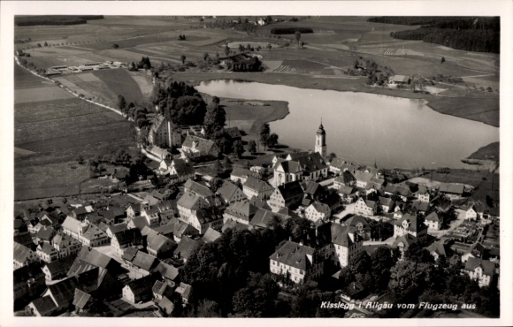 Ak Kißlegg im Allgäu, Luftaufnahme von  Dorfansicht, umgeben von Feldern und Wasser