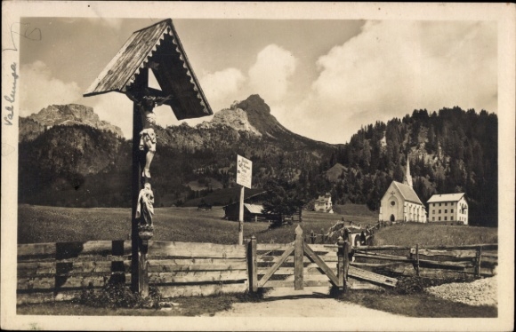 Ak Gröden Selva di Valgardena Südtirol, Landschaft mit Bergkulisse, Holzskulpturen, Kirche, Zaun