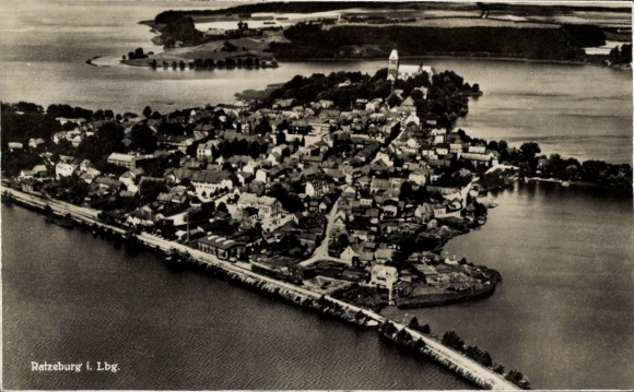 Ak Ratzeburg im Herzogtum Lauenburg, Luftaufnahme einer Stadt, Wasserflächen, viele Häuser, Baumg