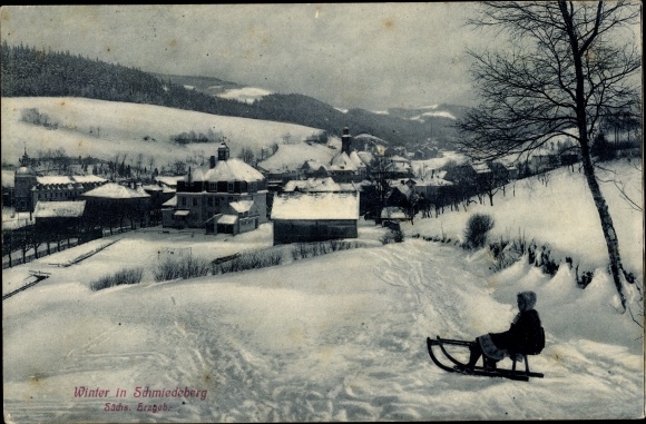 Postcard Schmiedeberg Dippoldiswalde in the Ore Mountains, view of the town in winter, girl with a sled