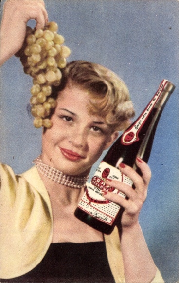 Postcard Blonde woman with wine bottle, grapes, advertising GRAP