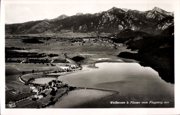 Ak Weißensee Füssen im Ostallgäu, Luftaufnahme vom Weißensee, Berge, Wiesen, Straßen, Häuser