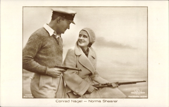 Ak Schauspieler Conrad Nagel und Norma Shearer, Portrait mit Gewehr und Pistole, Ross Verlag