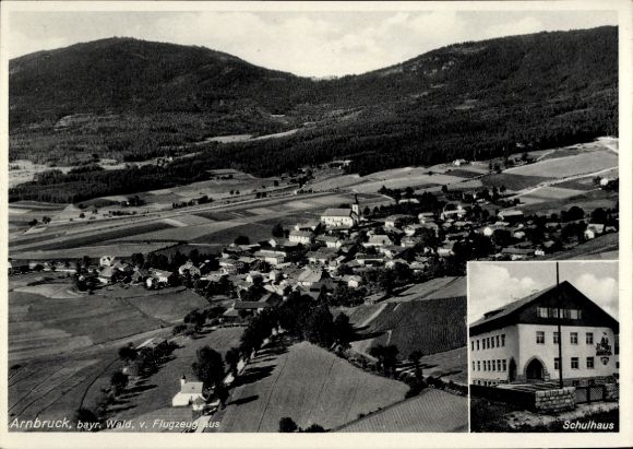 Ak Arnbruck im Bayerischen Wald Oberpfalz, Luftaufnahme von  Schulhaus, bewaldete Berge, ländlich