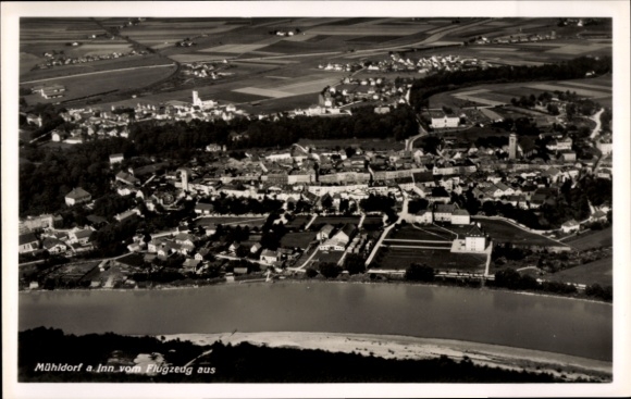 Ak Mühldorf am Inn Oberbayern, Luftaufnahme von Mühldorf a. Inn, Fluss und Landschaft im Hintergr