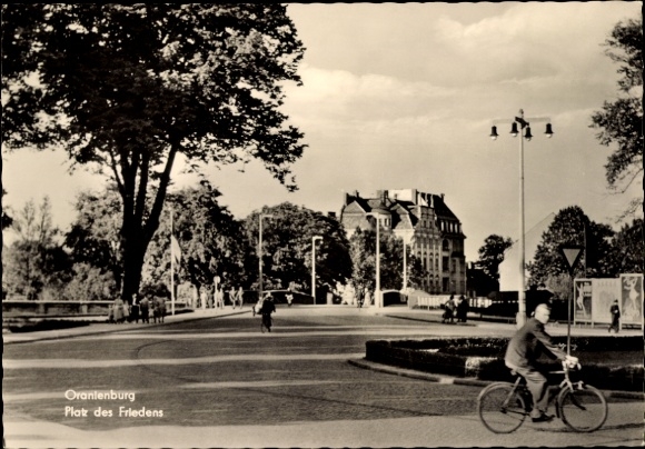 Postcard Oranienburg in Brandenburg, street scene with trees and buildings, a man with a bicycle is ...