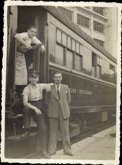 Photo Three men standing at railway, group photo, restaurant