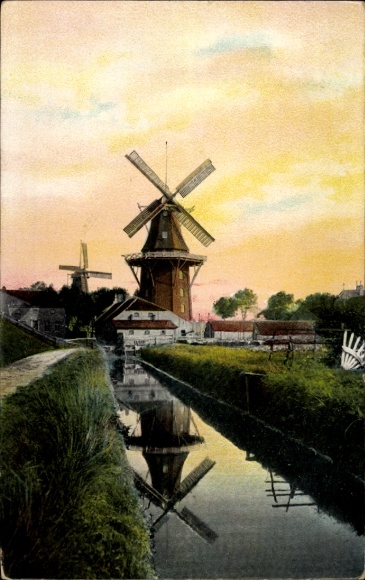 Postcard windmills, village motif at sunset