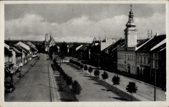 KP Rakovnik Rakonitz Środkowe Czechy, ulica z drzewami, domami, wieżą kościoła, czarno-białe zdjęcie
