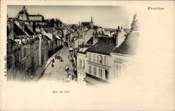 Ak Provins Seine et Marne, Schmaler Straßenzug, Gebäude, Bäume im Hintergrund, Schwarz-Weiß-Foto
