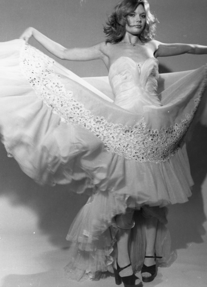 Foto Lilo Korenjak, Frau in Ballkleid hebt die Röcke, Plateauandalen