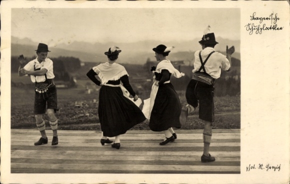 Postcard Schliersee in Upper Bavaria, 4 people in traditional costume dancing Schuhplattler in front of mountain scenery