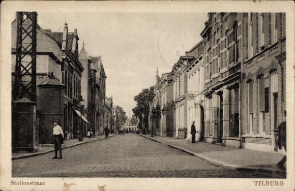Ak Tilburg Noord-Brabant Nederland, Stationstraat, oude architectuur, geplaveide straat, mannen...