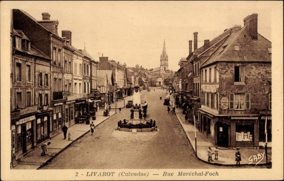Ak Livarot Calvados, Rue  Maréchal-Foch, Denkmal, Passanten