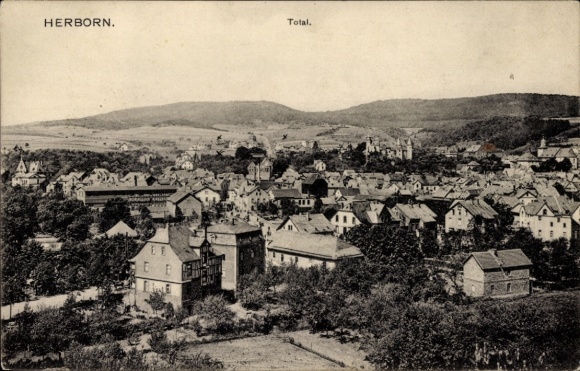 Postcard Herborn in Hesse, city view from many roofs, surrounding forests and hills