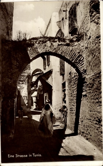 Ak Tunis Tunesien, Eine Straßenszene, Altstadt, Bogen, Personen in traditioneller Kleidung