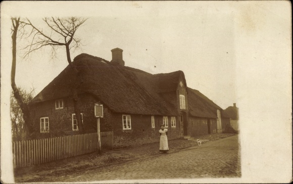 Photo Postcard Christian Albrechts Koog Galmsbüll in North Friesland, woman in front of a house with a thatched roof