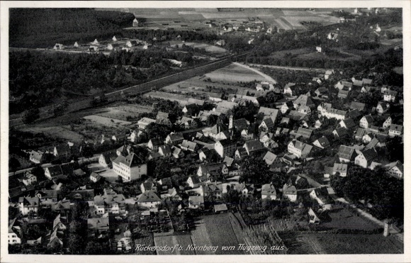 Ak Rückersdorf in Mittelfranken, Luftaufnahme von Rückersdorf, Häuser, Landschaft, Bahntrasse