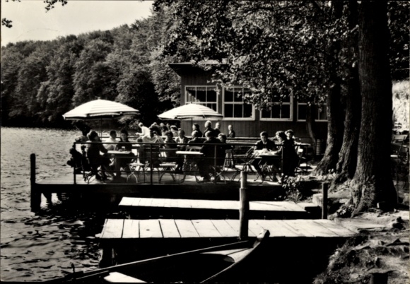 Ansichtkaart Feldberg in Mecklenburg, mensen aan het meer, houten steiger, parasols, gebouwen op de achtergrond