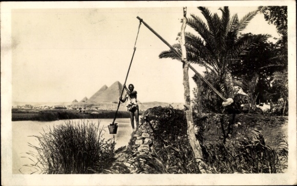 Ak Gizeh, Egypte, man die water put aan de oevers van de Nijl, piramides