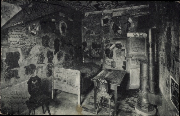 Postcard Heidelberg am Neckar, room with bed, table, chair, walls covered with graffiti, writings