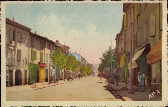 Postcard Carmaux Tarn, colorful street with trees, various buildings and shops, clear skies.