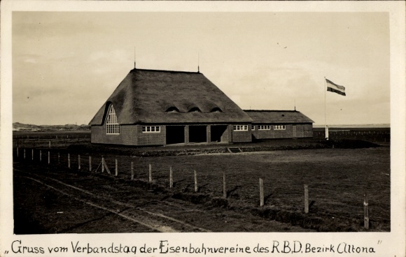 Ak Eiland Sylt in Noord-Friesland, huizen met rieten daken, vlag, belettering: Groeten van de Verenigingsdag de