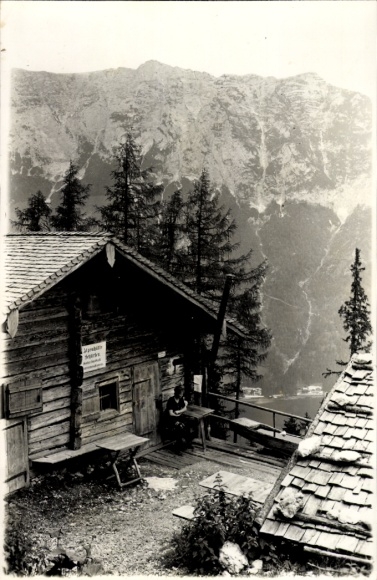Postcard Ramsau in Berchtesgadener Land Upper Bavaria, hut in the mountains, man sitting, high mountains in the background
