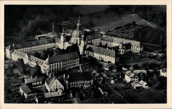 Ak Ettal Oberbayern, Luftaufnahme von  Abtei, Gebäude, Berge, Wald