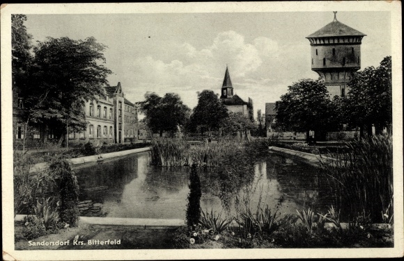 Ansichtkaart Sandersdorf Brehna in Saksen-Anhalt, kavel bij de watertoren met cath. Kerk, August Bebel School