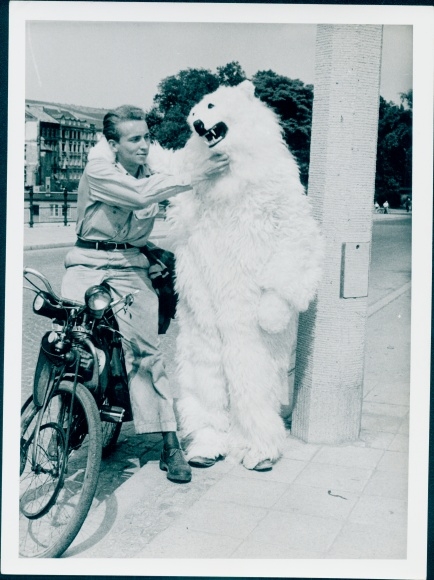 Photo Young man on a bicycle, person in polar bear costume