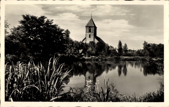 Postcard Achern in Baden Black Forest, church in the city park, water surface with reflection, green riverside vegetation
