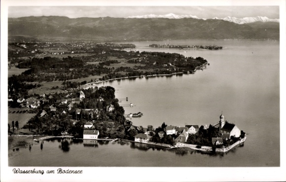 Ak Wasserburg am Bodensee Schwaben, Luftaufnahme von Wasserburg, Bodensee, Berge im Hintergrund