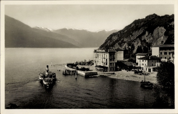 Ak Varenna Lombardia, Schiff im Hafen, Berglandschaft, Gebäude am Ufer, ruhiges Wasser