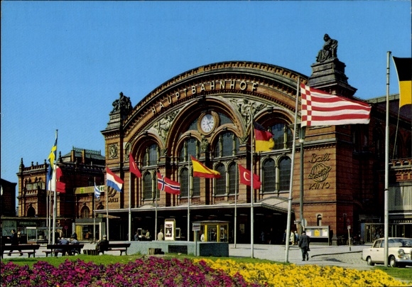 Ak Hansestadt Bremen, Hauptbahnhof, Frotnal, bunte Flaggen, Blumenrabatte