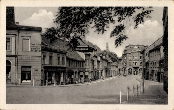 Postcard Lutherstadt Eisleben, front side showing a street, buildings, cloudy sky.