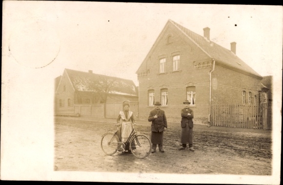foto Ak Rehsen Oranienbaum Wörlitz in Anhalt, huizen, familie Schmidt, vrouw met fiets, twee mannen
