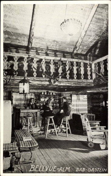 Ak Bad Gastein Badgastein in Salzburg, BELLVUE-ALM, interieur, twee personen aan tafel, rustiek
