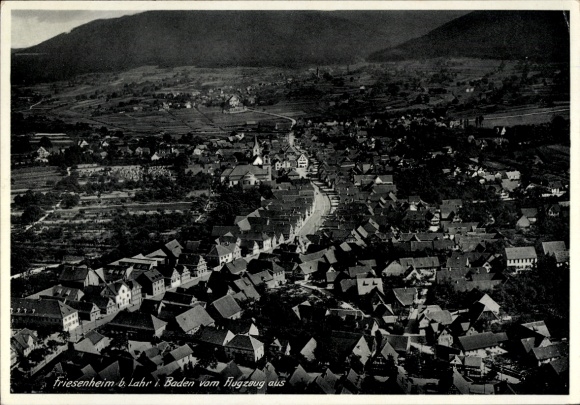 Ak Friesenheim in Baden, Luftaufnahme von Friesenheim, viele Dächer, Berge im Hintergrund