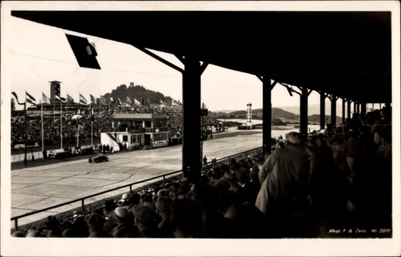Postcard Nürburg in the Eifel, Nürburgring, racing car, spectator stands, flags, Nürburg in the background