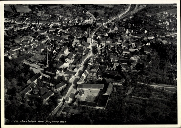 Ak Sandersleben in Anhalt, luchtfoto van huizen, kerk, zijstraat