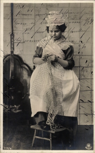 Postcard girl in traditional costume knotting a net